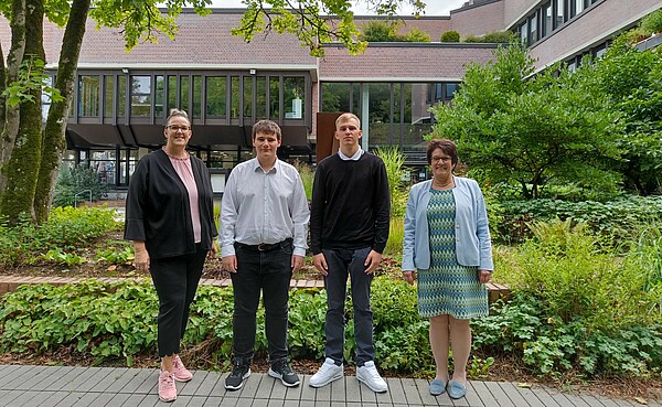 Das Bild zeigt die zwei neuen Azubis mit ihrer Ausbildungsleiterin und der Bürgermeisterin vor dem Rathaus